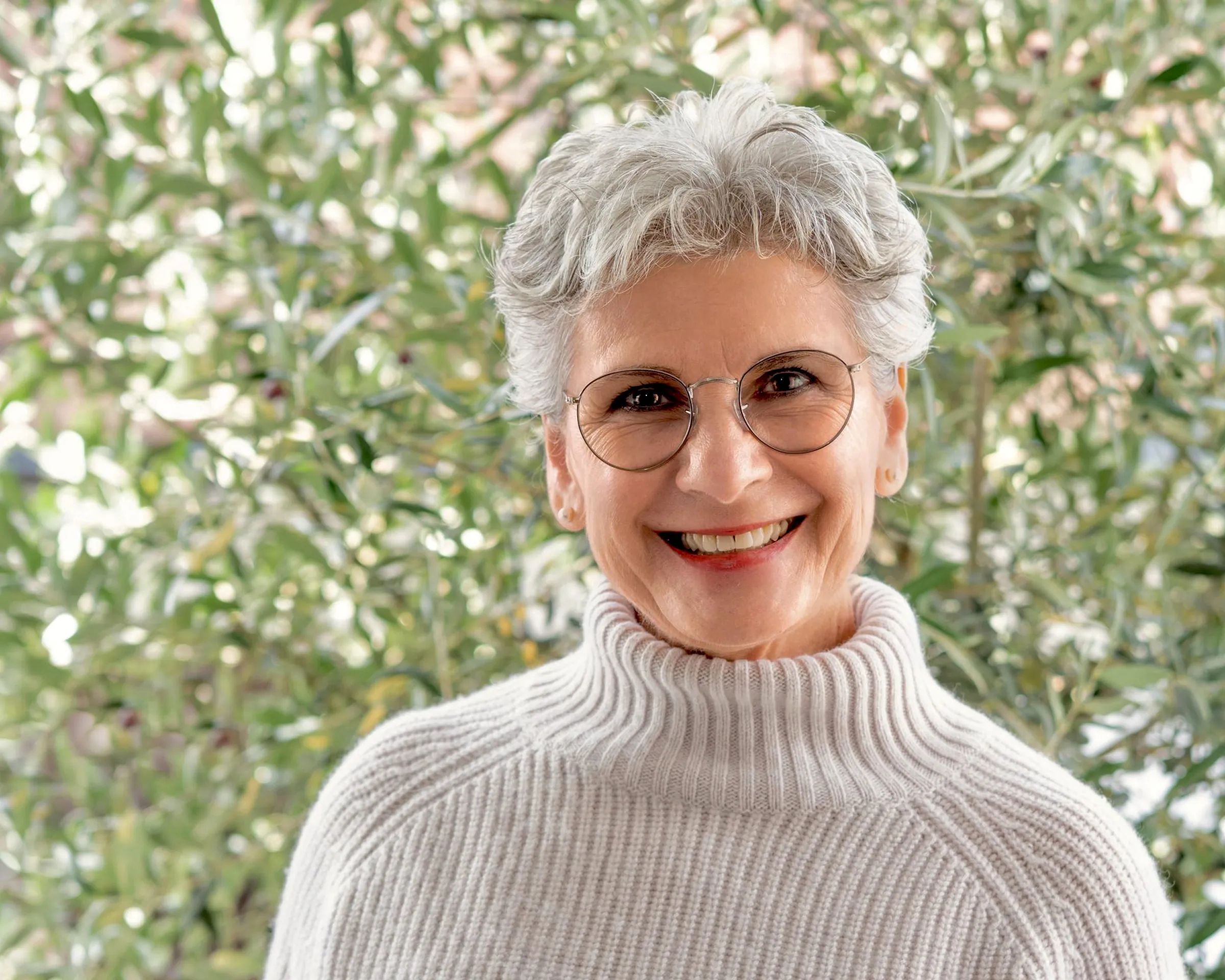 Astrid Schweizer, Heilpraktikerin, vor einem Olivenbaum im Tageslicht