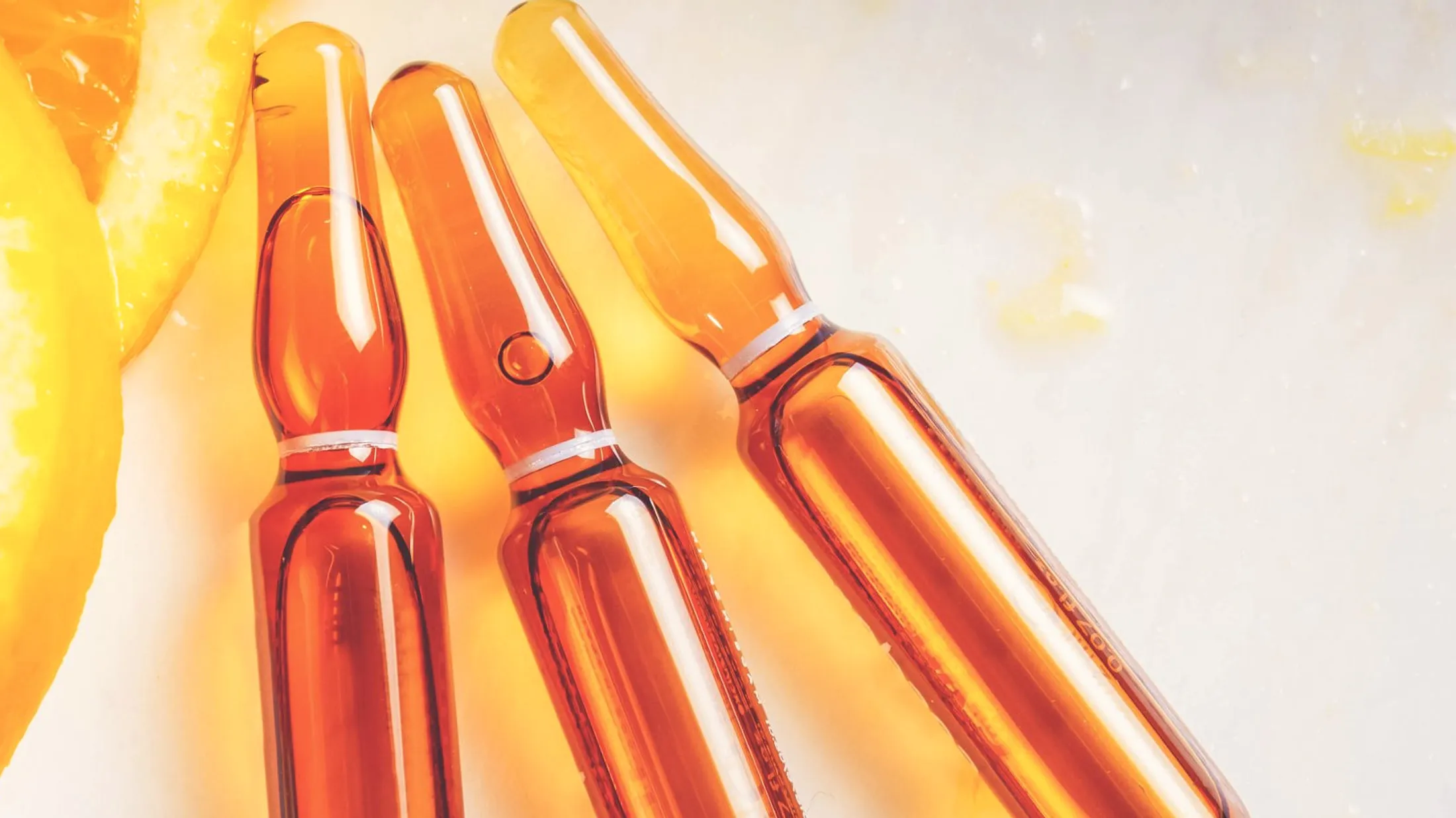 Ampullen neben einer aufgeschnittenen Orange