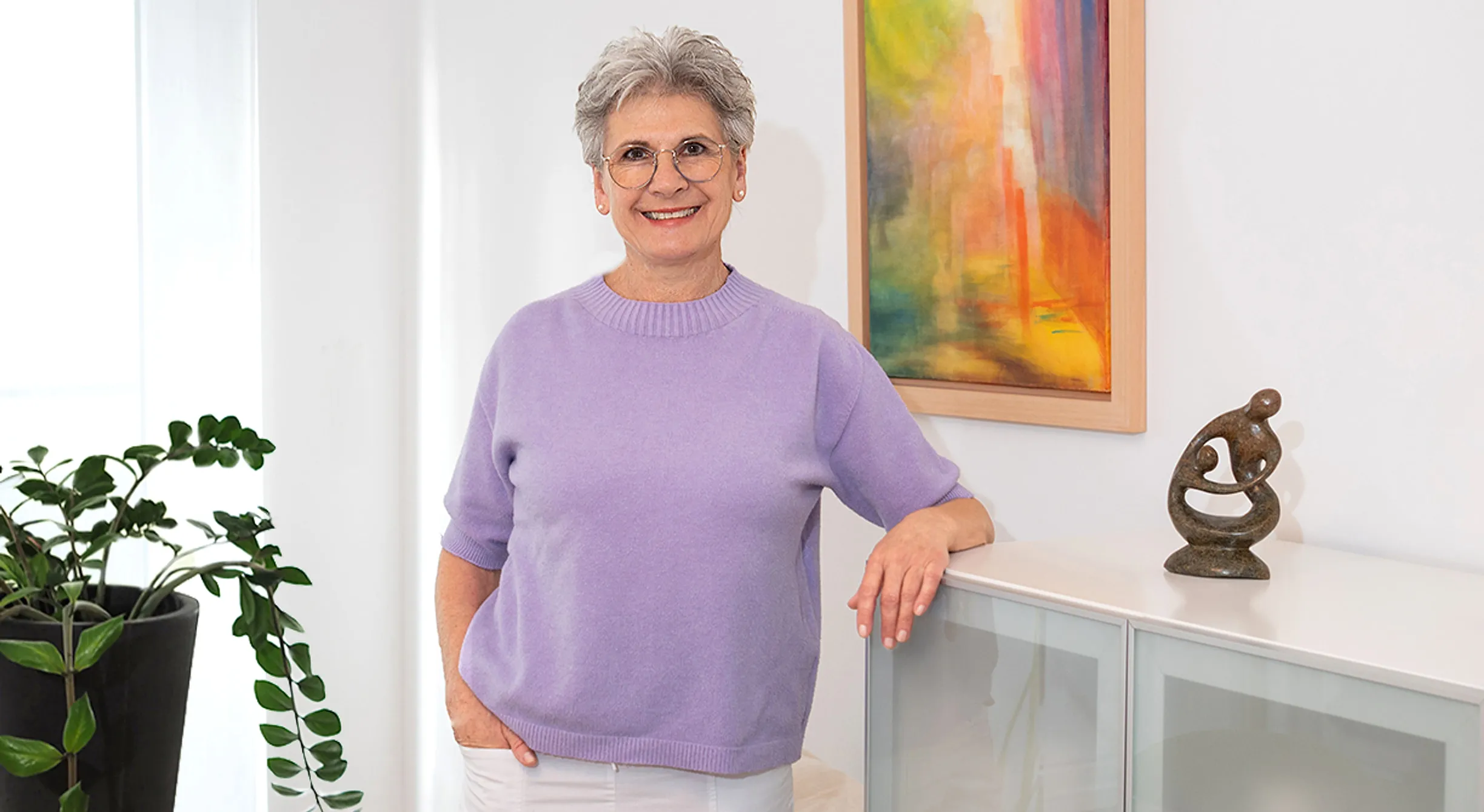 Astrid Schweizer in ihrer Praxis, neben ihr auf dem Sideboard die Steinskulptur